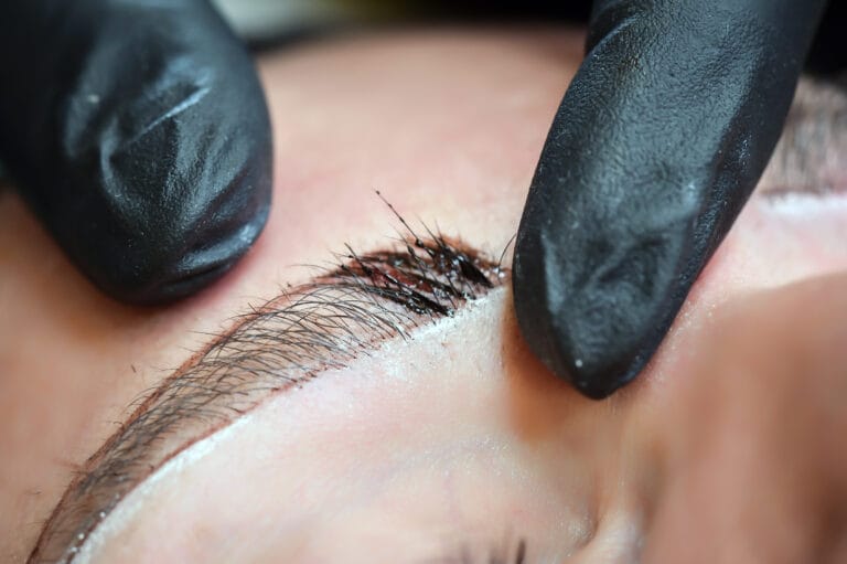 Microblading eyebrows, getting facial care and tattoo at beauty